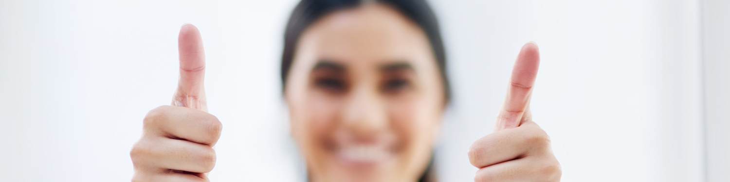 Fotografi av ei dame som viser to tomlar opp